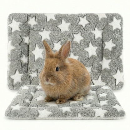 Small brown rabbit sitting on a gray mat with white star patterns